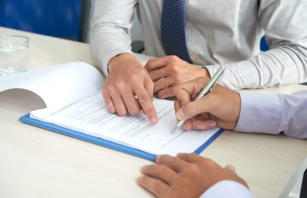 Businessman showing his partner where to sign the contract