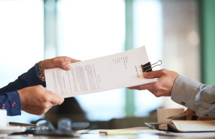 Business person giving partnership agreement to coworker