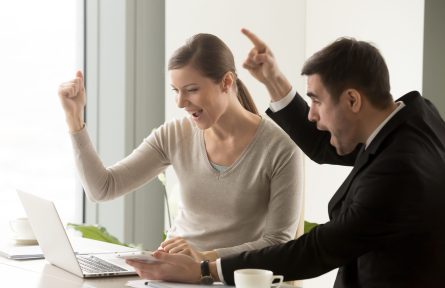 Euphoric happy businesspeople amazed by big win, looking at laptop screen, cheering supporting while watching broadcast, winners celebrating business success, online auction, great luck, good result